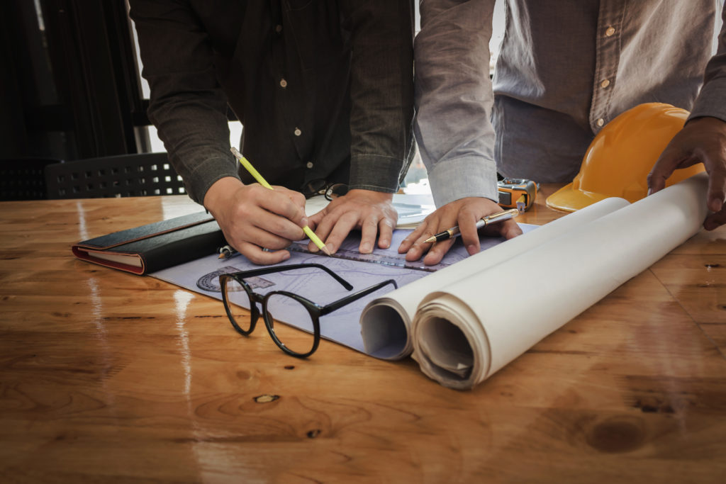 People drafting a new architecture project at a drafting table