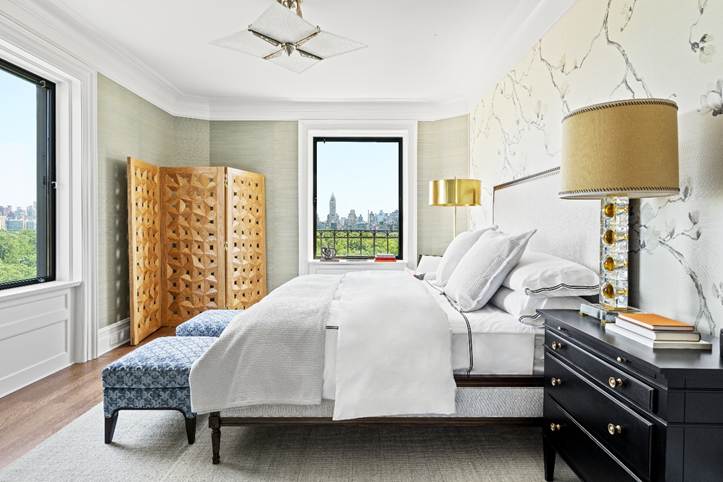 A bedroom with a view of the New York City skyline